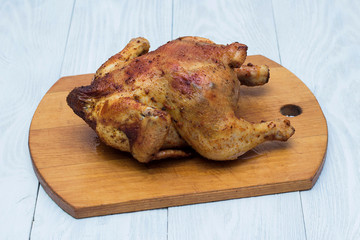 whole fried chicken in spices on a wooden tray