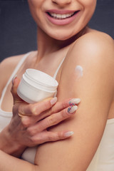 Obraz na płótnie Canvas Woman applying body lotion.