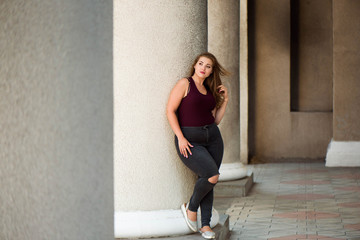 Young stylish woman walking on the city street in summer. Plus size model.
