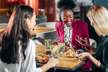 Three women eating healthy salads and drinking lemonade