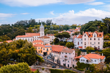 Group of buildings in a village surrounded by forest trees in the old town near the Palace of Sintra. Lisbon, Portugal.