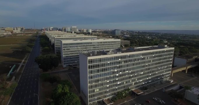 Brasilia aerial rising over Ministry Buildings with sun reflecting on window