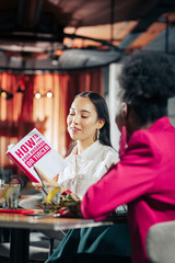 Single dark-haired businesswoman reading book about finding love