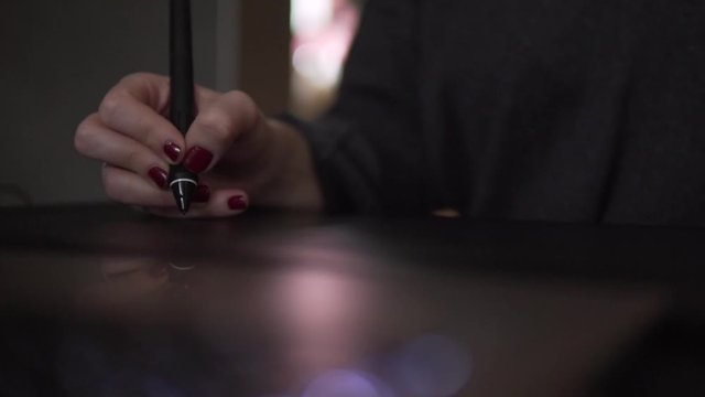 SLOW MOTION: Close Up of womans hand with digital pen on graphic tablet