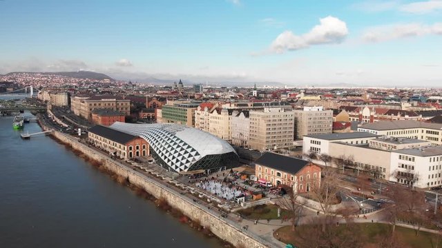 Aerial shot flying down to the Balna Cultural Centre near The Danube and beautiful waterfront in Budapest, Hungary