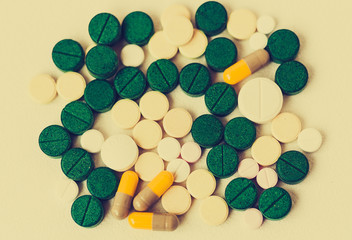 Medicine green, pink and yellow pills or capsules on white background with copy space. Drug prescription for treatment medication. Blister pack.