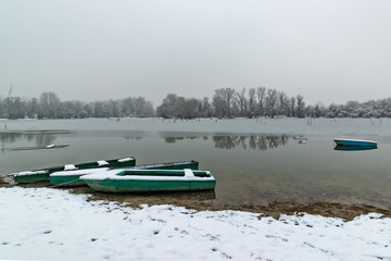 Naklejka premium Beautiful frozen river. A boats covered with snow.