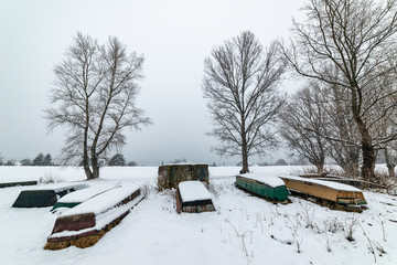 Naklejka premium A boats covered with snow on the coast