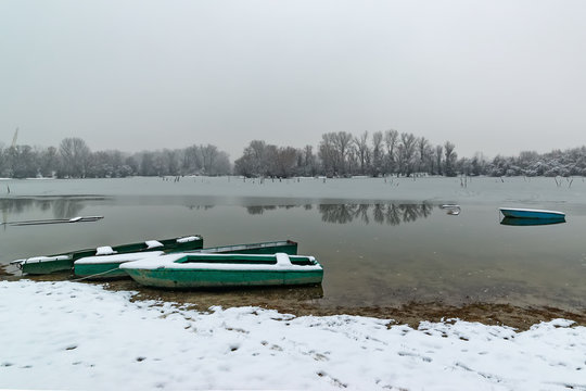 Beautiful frozen river. A boats covered with snow.