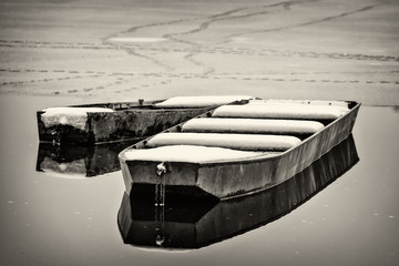 Naklejka premium Beautiful frozen river. A boats covered with snow.