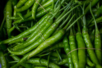 Close up view of a pile of green chilli pepper at a fresh market bazaar