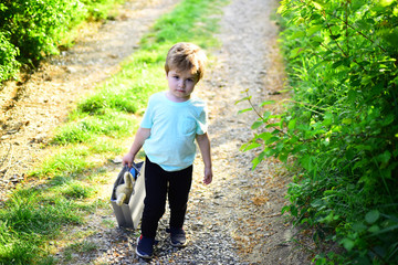 spring holiday. Sunny weather. Small child with toy in shopping bag. summer. Little boy child in green forest. Happy kid in blooming nature. Childhood happiness. Childrens day. Wonderful trip