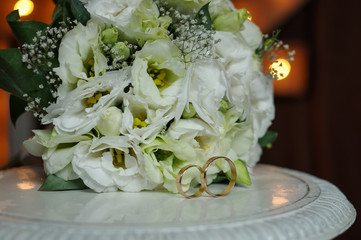 Horizontal shot of wedding rings with a bouquet of the bride. The concept of a wedding day