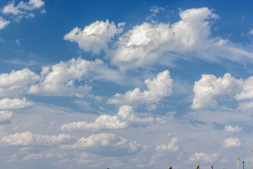 a lot of cumulus white clouds in bright blue summer sky
