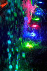 splashes of a colored fountain in the dark