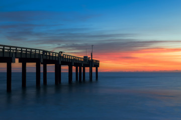 Fototapeta na wymiar Sunrise over the Atlantic Ocean at the St. Augustine Beach Pier in St. Augustine, Florida