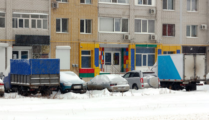 row of cars parked in the snow
