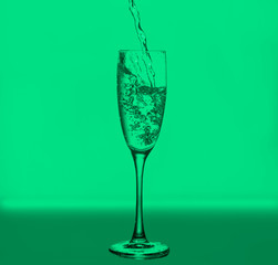 wineglass  with bubbles and drops on  turquoise background