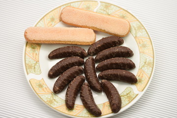 chocolate bananas and ladyfingers  on a porcelain plate