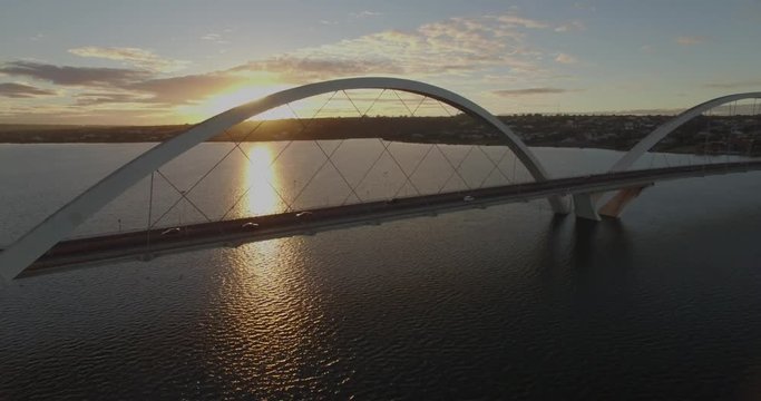 Brasilia Aerial - sun rising through Juscelino Kubitsheck Bridge, temporarily eclipsed by the arch structure