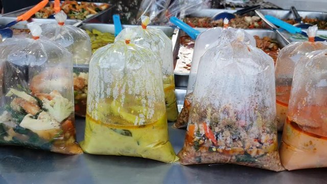 Street trade : thai vendor prepares and sells food at street food market in Thailand 