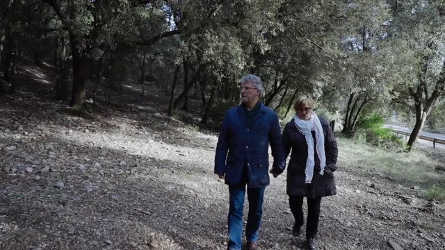 Senior couple walking through the woods