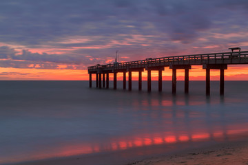 Fototapeta na wymiar Sunrise over the Atlantic Ocean at St. Augustine Beach Pier in St. Augustine, Florida