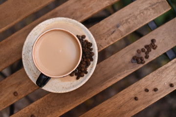 Cup of coffee with coffee beans on a wooden table