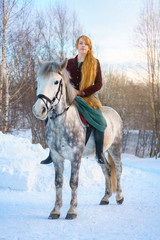 young woman with long hair with horse in winter