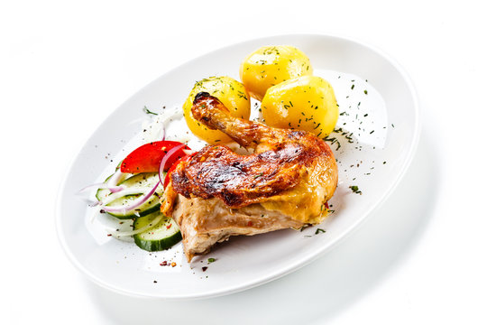 Grilled chicken leg with vegetables on white background