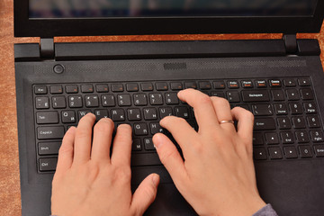 female hands print on the laptop keyboard