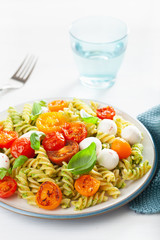 healthy fusilli pasta with pesto sauce, roasted tomatoes, mozzarella