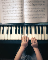 Children's hands learn to play the piano