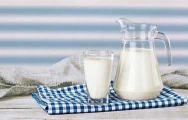 Glass of milk and bottle on  background