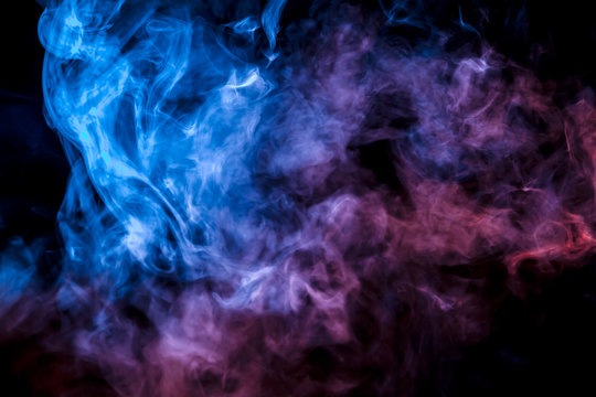 A colorful pillar of blue, pink and purple smoke evaporates with thin jets rising to the top on a black background in neon light.