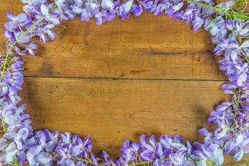 Beautiful frame of blooming purple wisteria on vintage wooden background with copy space