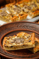 Homemade tart with mushrooms, leek, cheese and thyme on rustic background. Traditional snack cake. Lunch or dinner for gourmets. Selective focus