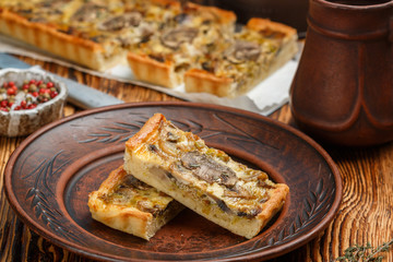 Homemade tart with mushrooms, leek, cheese and thyme on rustic background. Traditional snack cake. Lunch or dinner for gourmets. Selective focus