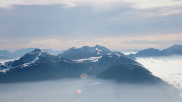 View from the top of the Paganella mountain in Trentino, Italy. Other peaks with slowly moving clouds at their bottom.