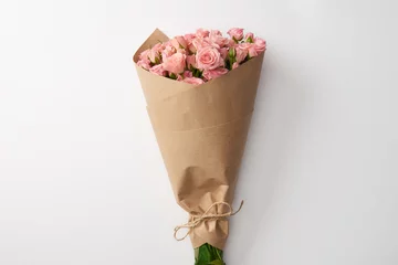 Poster bouquet of beautiful pink roses wrapped in craft paper on grey © LIGHTFIELD STUDIOS