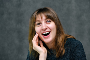 Concept portrait beautiful young brunette woman face close up studio on gray
