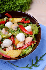 Salad with chicken, roasted potato, mozzarella cheese and red pepper in a bowl