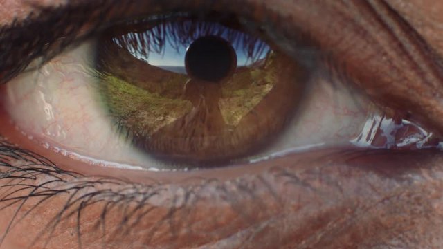 close up eye opening beautiful brown iris with reflection