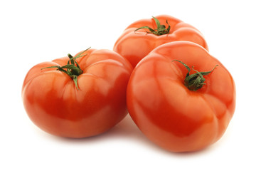 three fresh beef tomatoes on a white background