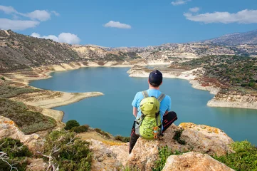 Tragetasche Tourist mit Rucksack betrachtet einen schönen Stausee von einer Aussichtsplattform in Zypern © tns2710