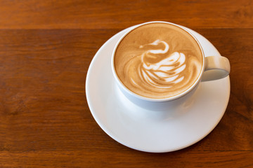 Latte art coffee cup swan shape topping on wooden table