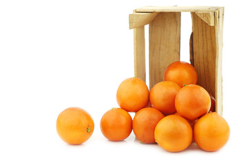 fresh blood oranges in a wooden crate on a white background