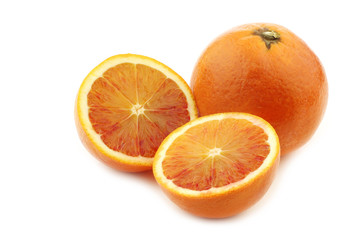 fresh blood orange and a cut one on a white background
