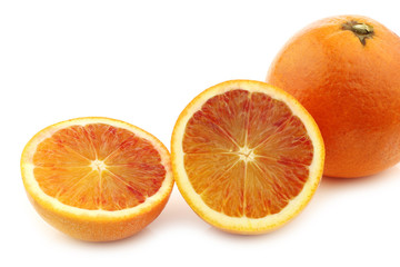fresh blood orange and a cut one on a white background