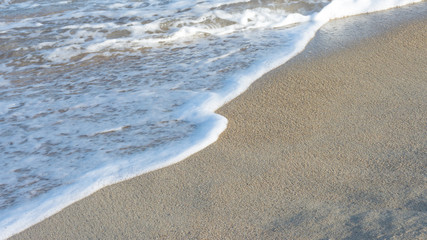 foam wave on the sandy shore